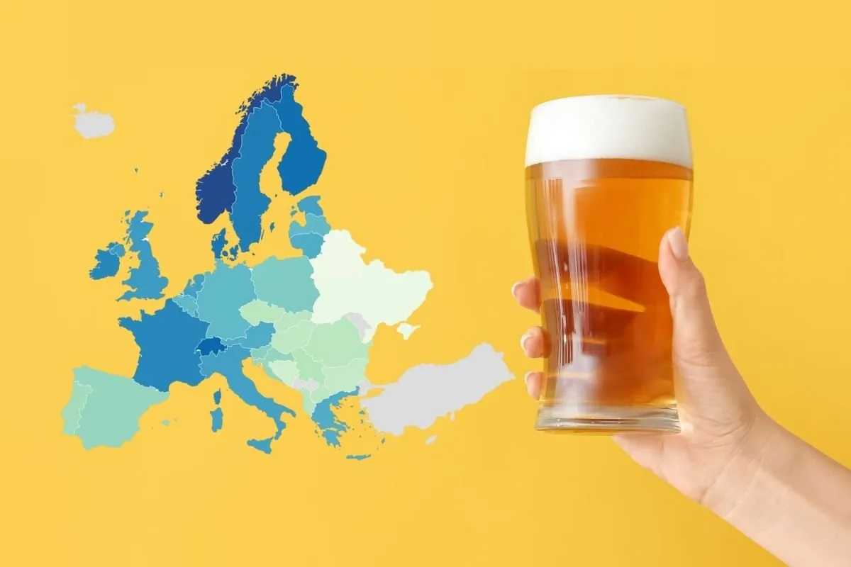 Eine Hand hält ein Glas Bier mit Schaumkrone neben einer Europakarte in Blautönen, auf gelbem Hintergrund