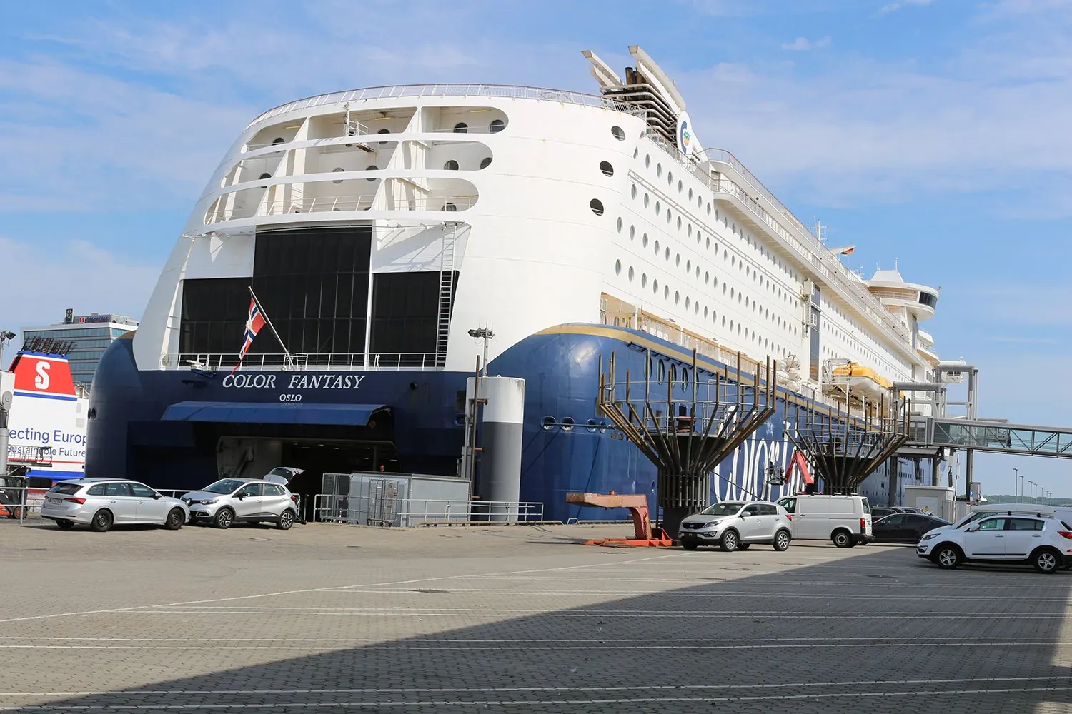 Die Color Fantasy am Kai in Kiel, mit Autos daneben auf dem Terminalgelände