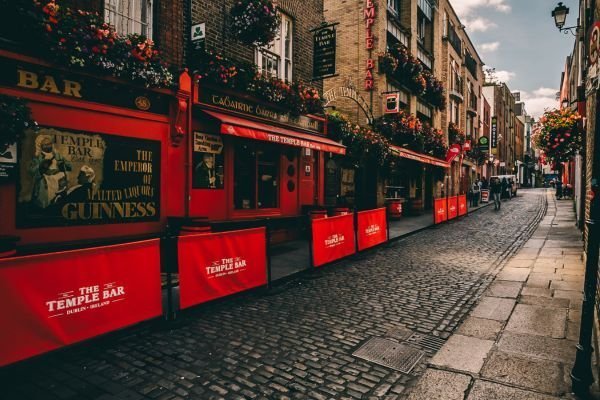 Die rote Fassade von The Temple Bar an einer gepflasterten Straße in Dublin