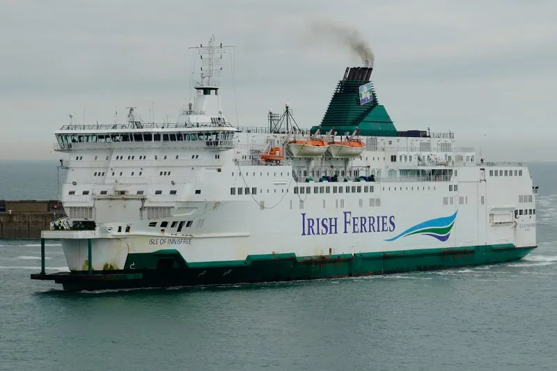 Die Isle of Innisfree von Irish Ferries, weiß und grün, mit Rauch aus dem Schornstein und Roststellen am Rumpf
