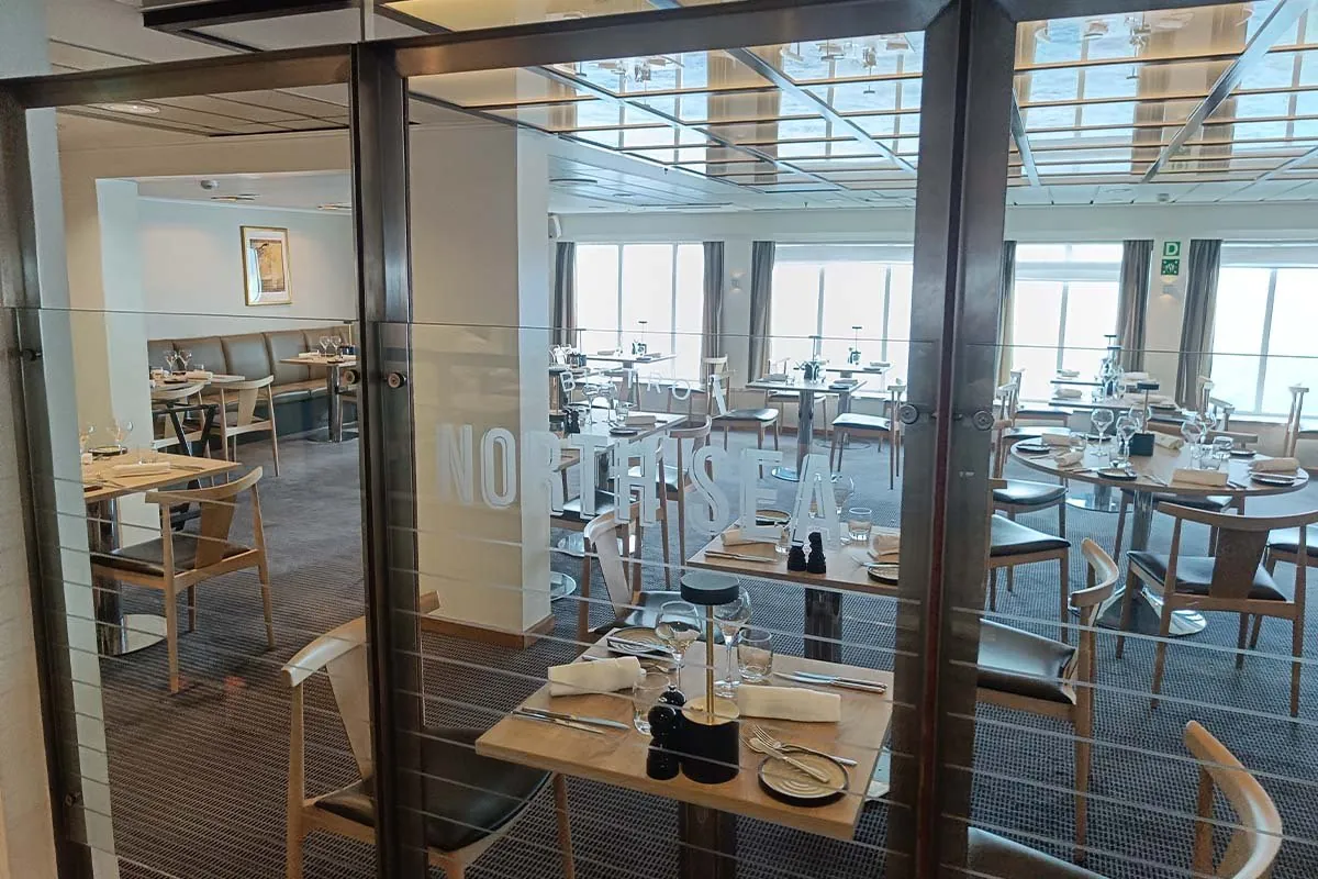 Gedeckte Tische hinter der Glastür des North Sea Bistro