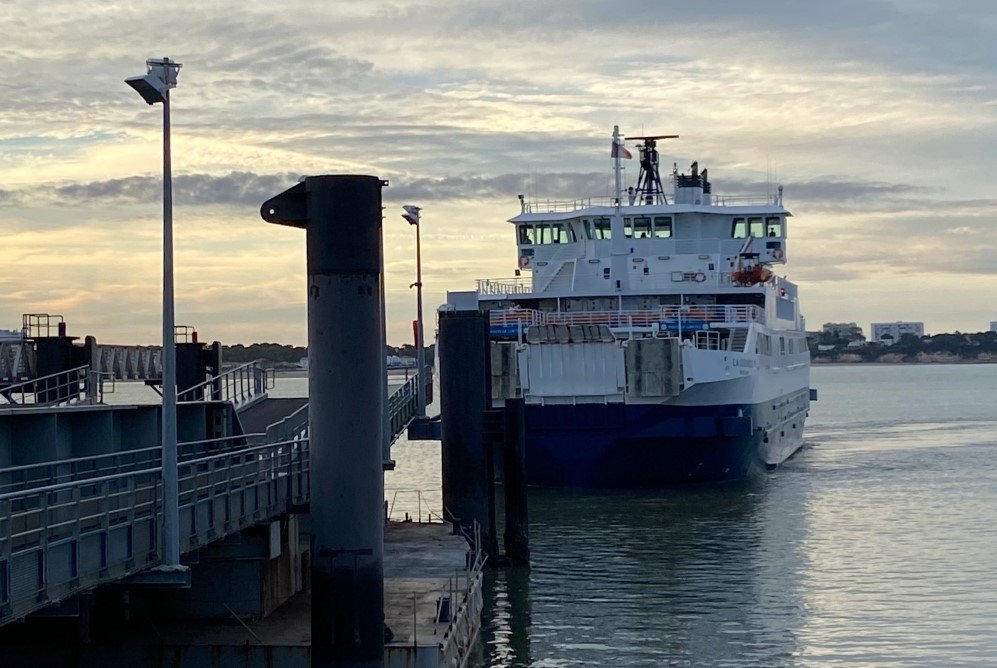 Die La Gironde kommt im tiefen Sonnenlicht zum Anleger, links vorn ein stählerner Poller und eine Gangway