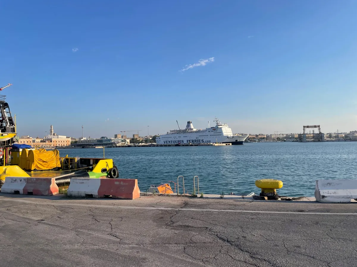 Die weiße Fähre Rigel III von Ventouris Ferries am Kai im Hafen von Bari, mit der Altstadt im Hintergrund
