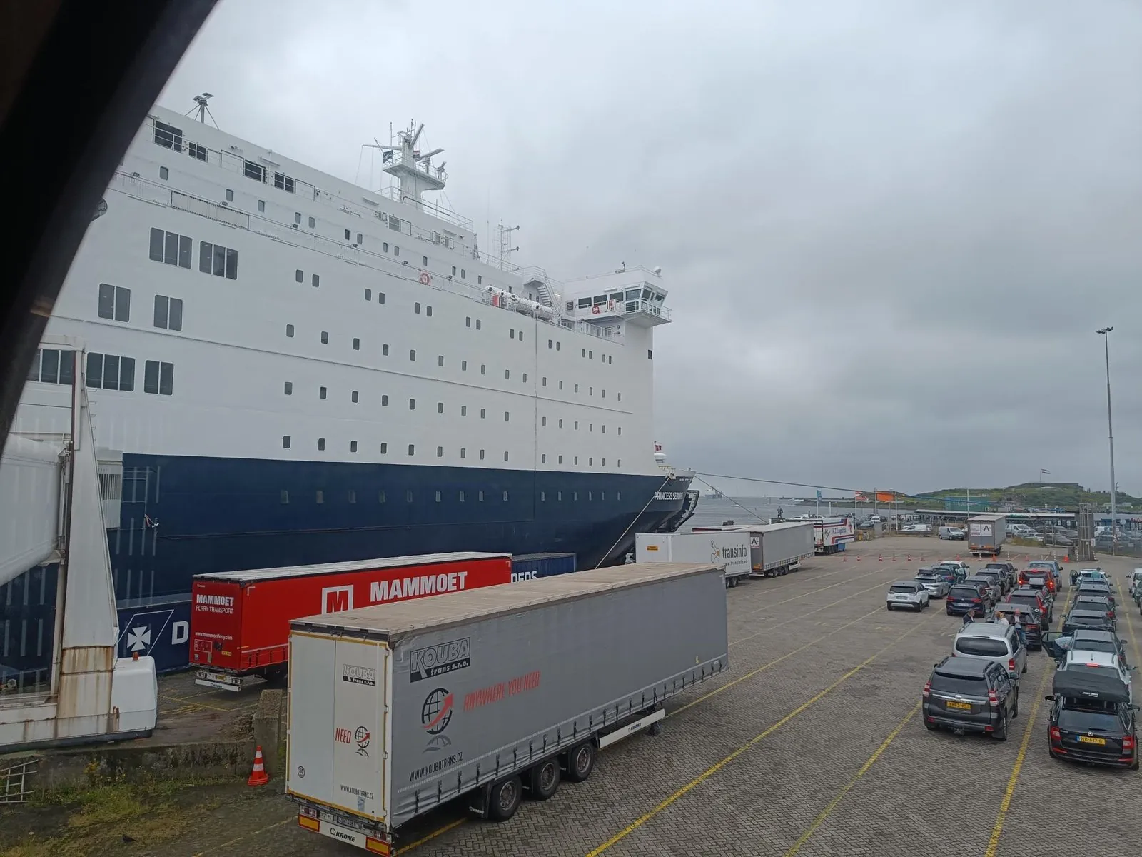 Die Princess Seaways am Kai in IJmuiden mit Sattelaufliegern davor und Reihen von Autos, die auf das Boarding warten