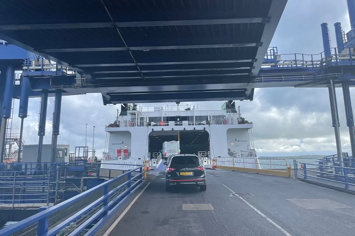 Ein Transporter und ein Auto fahren über die Laderampe in das offene Heck der Dublin Swift, mit dem Schiffsnamen auf beiden Rümpfen