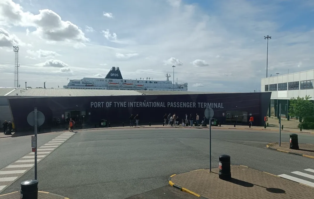 Das Gebäude des Port of Tyne International Passenger Terminal in North Shields, mit der DFDS-Fähre dahinter