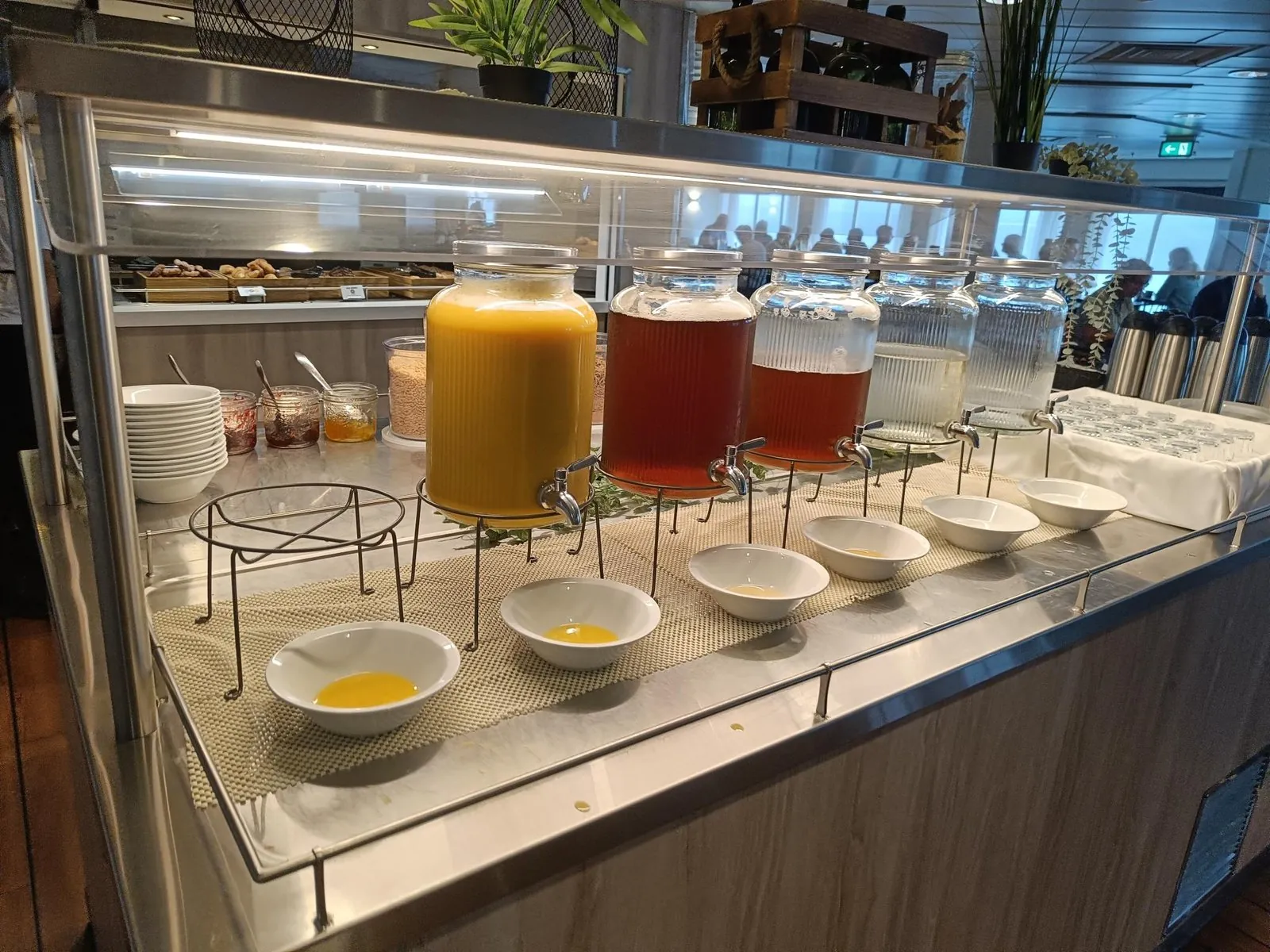 Das Frühstücksbuffet mit Saftspendern aus Glas, Schalen, Müsli und Kaffeekannen